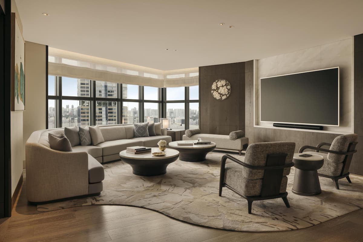 Una sala de estar moderna con un ventanal grande, un televisor de pantalla plana y un sofá modular.