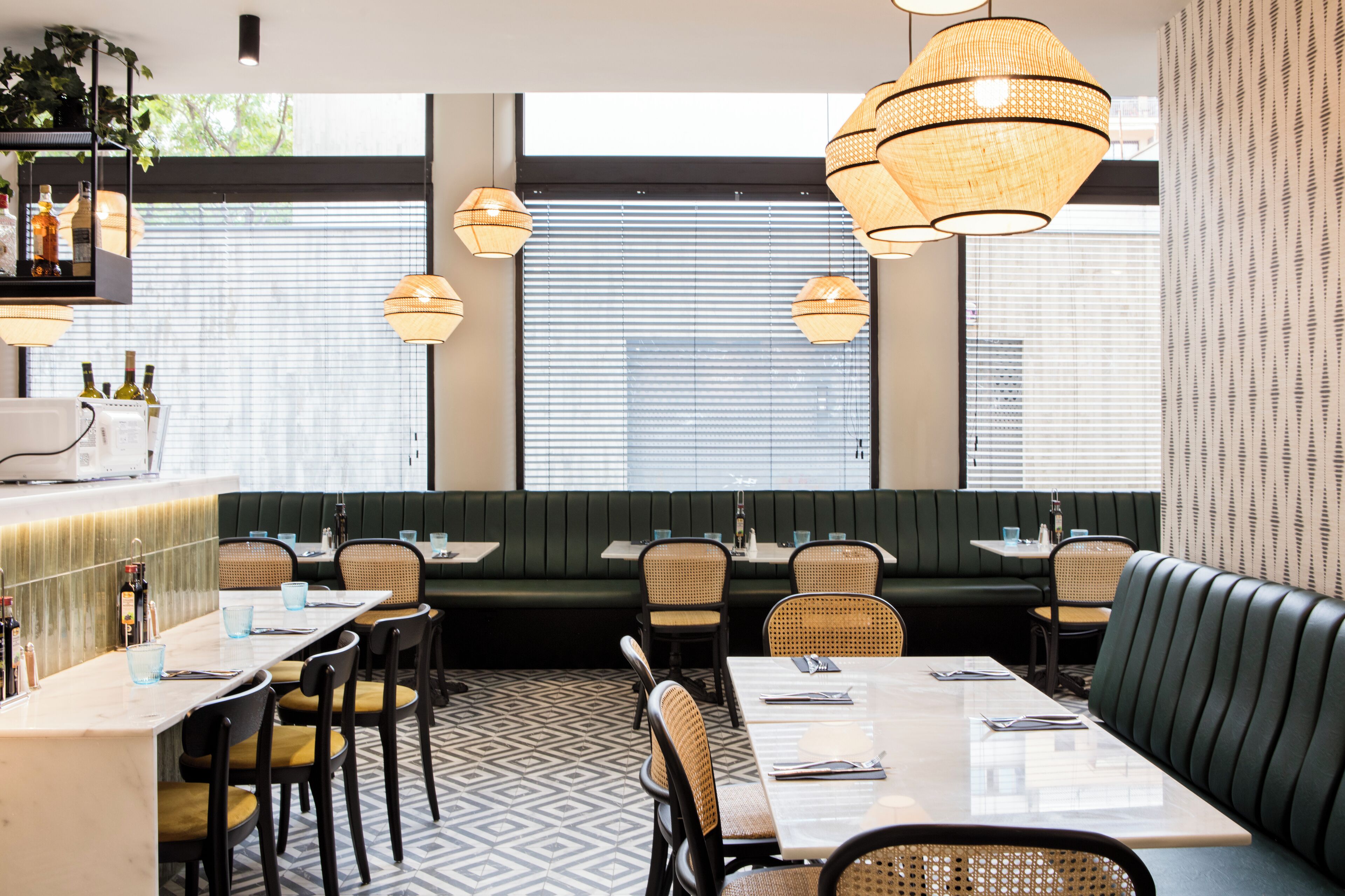 Un restaurante con barra, cabinas y mesas.