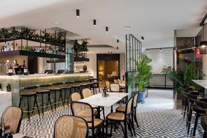 Uma área de bar moderna com balcão, banquetes e piso estampado.