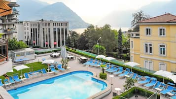 Una piscina al aire libre de temporada, sombrillas, tumbonas