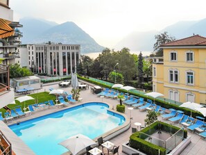 Una piscina al aire libre de temporada, sombrillas
