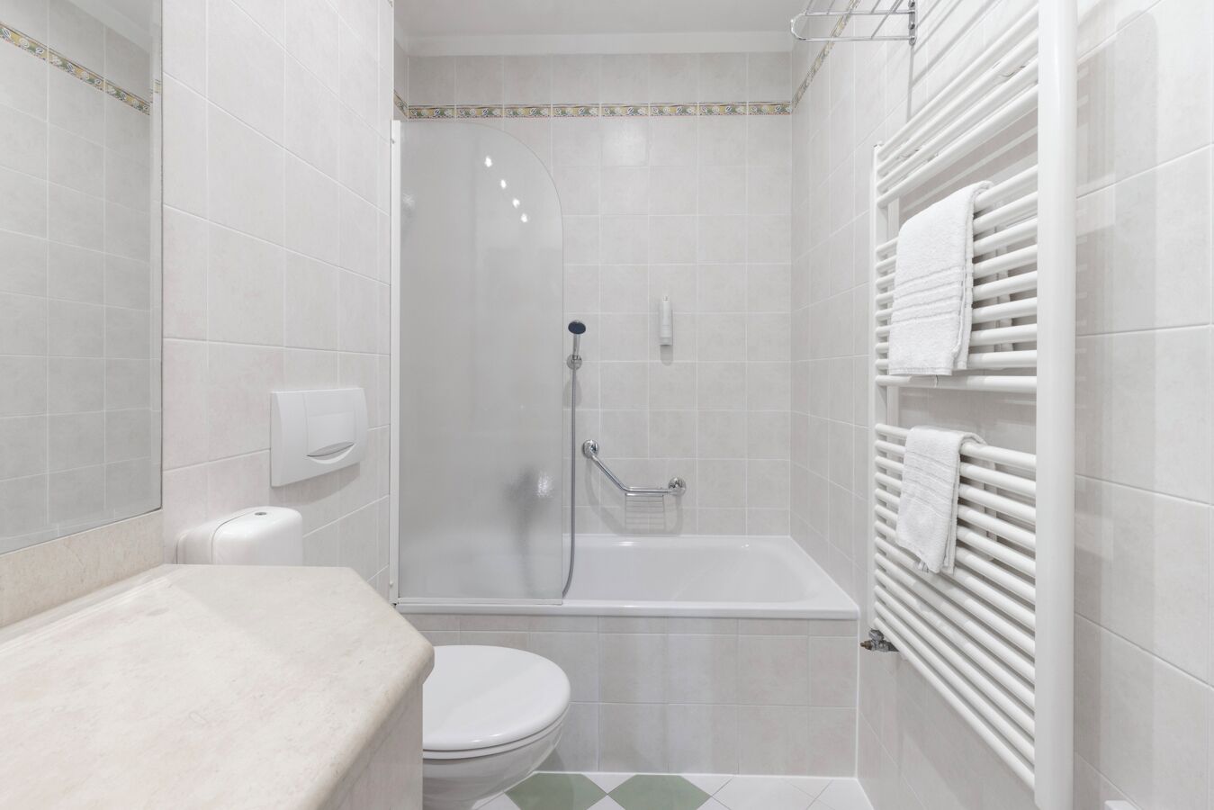 Une salle de bain moderne équipée d’une douche, de toilettes et d’un porte-serviettes.