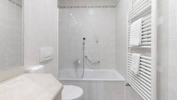 Une salle de bain moderne équipée d’une douche, de toilettes et d’un porte-serviettes.