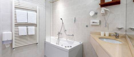 Un baño moderno con bañera, lavamanos y barra para toallas.