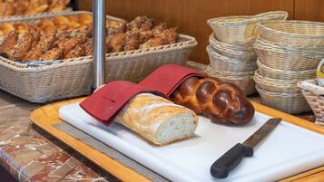 Een snijplank met een brood en een mes.