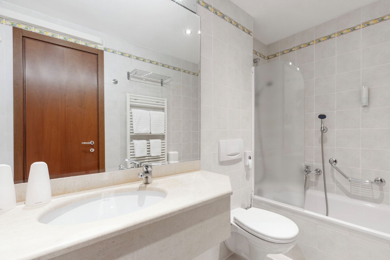 A modern bathroom with a large sink, toilet, and walk-in shower.