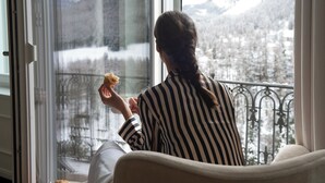 A person sitting by a window with a view of snow-covered mountains. - Grand Hotel Kronenhof (Pontresina)
