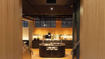 Une cuisine moderne dotée d’un îlot central, d’appareils électroménagers intégrés et offrant une vue sur la ville grâce à de grandes fenêtres.