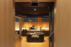 A modern kitchen with a central island, built-in appliances, and a view of the city through large windows. - Fred Hotel Central (Zürich)