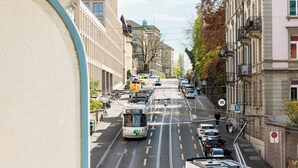 A tram on a city street with buildings on both sides. - Fred Hotel Central (Zürich)