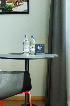 A table with two water bottles and a welcome card for Fred Hotels Zurich. - Fred Hotel Central (Zürich)