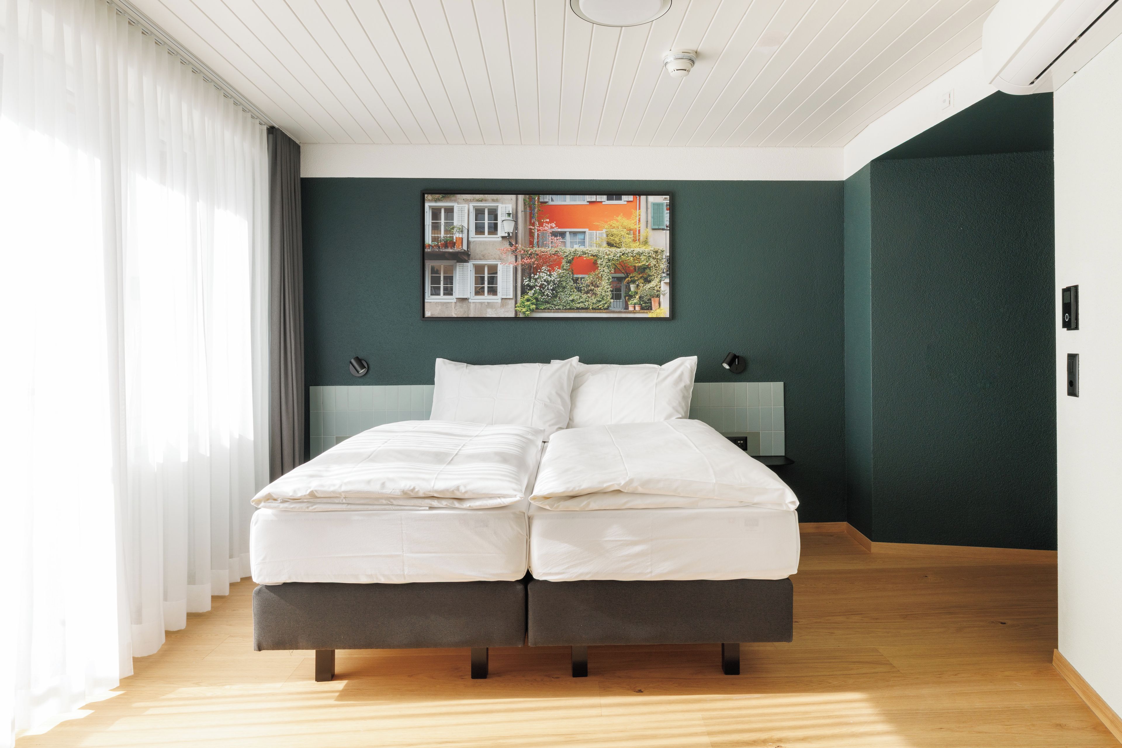 Un dormitorio moderno con cama, mesita de noche y un cuadro en la pared.