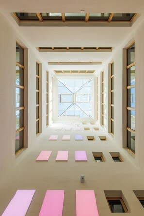 A modern interior with a central skylight and multiple windows. - Fred Hotel Central (Zürich)