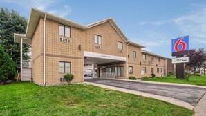 A 6 Motel with a clear entrance, a covered parking area, and a sign indicating free WiFi and renovated rooms. - Motel 6 Windsor, ON (Windsor)