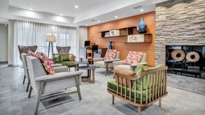 A modern living room with sofas, a coffee table, and a fireplace. - Fairfield Inn & Suites Fort Worth/Fossil Creek (Fort Worth)
