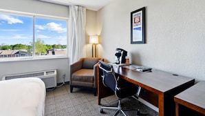 A hotel room with a bed, a desk with a chair, a lamp, and a framed map on the wall. - Comfort Inn South Tulsa - Woodland Hills (Tulsa)