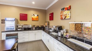 A breakfast area with a refrigerator, coffee machines, and a buffet counter with various food items. - Comfort Inn South Tulsa - Woodland Hills (Tulsa)