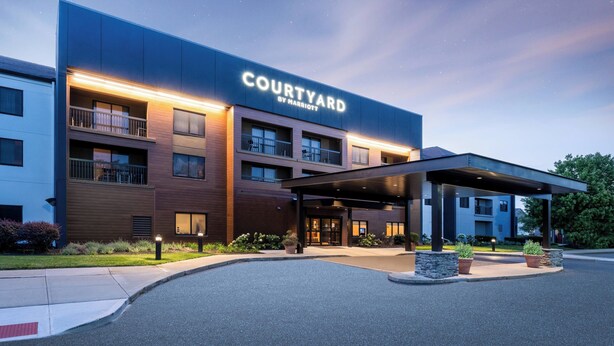 A Courtyard by Marriott hotel with a modern design, multiple balconies, and a covered entrance. - Courtyard by Marriott Columbus Airport (Columbus)