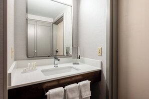 A modern bathroom with a white sink, a large mirror, and a wooden vanity. - Courtyard by Marriott Columbus Airport (Columbus)