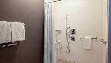 Un baño con ducha, toallero y retrete.
