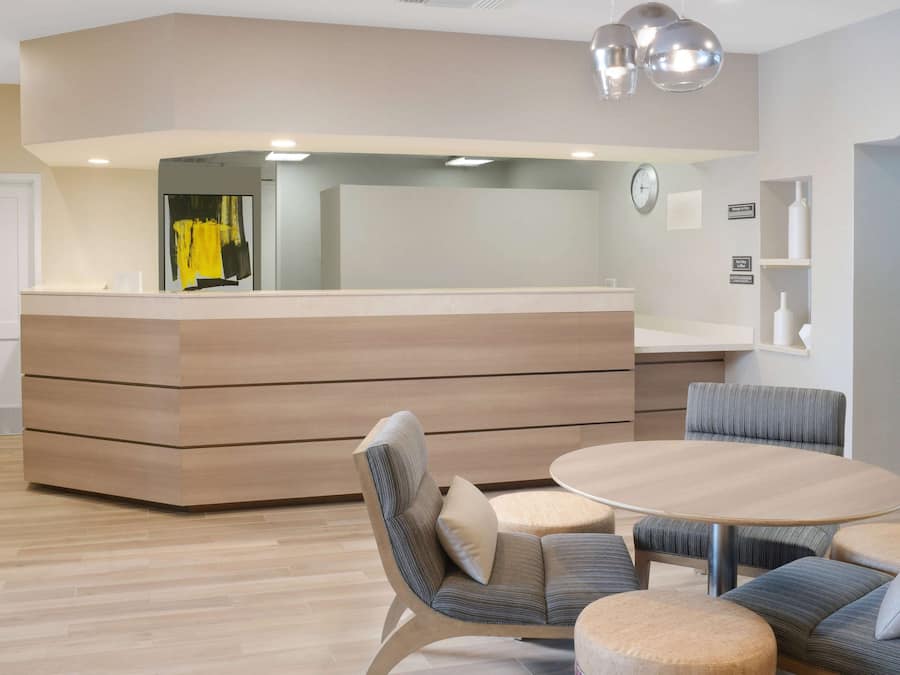 A modern kitchen with a built-in island, a round dining table, and contemporary chairs.