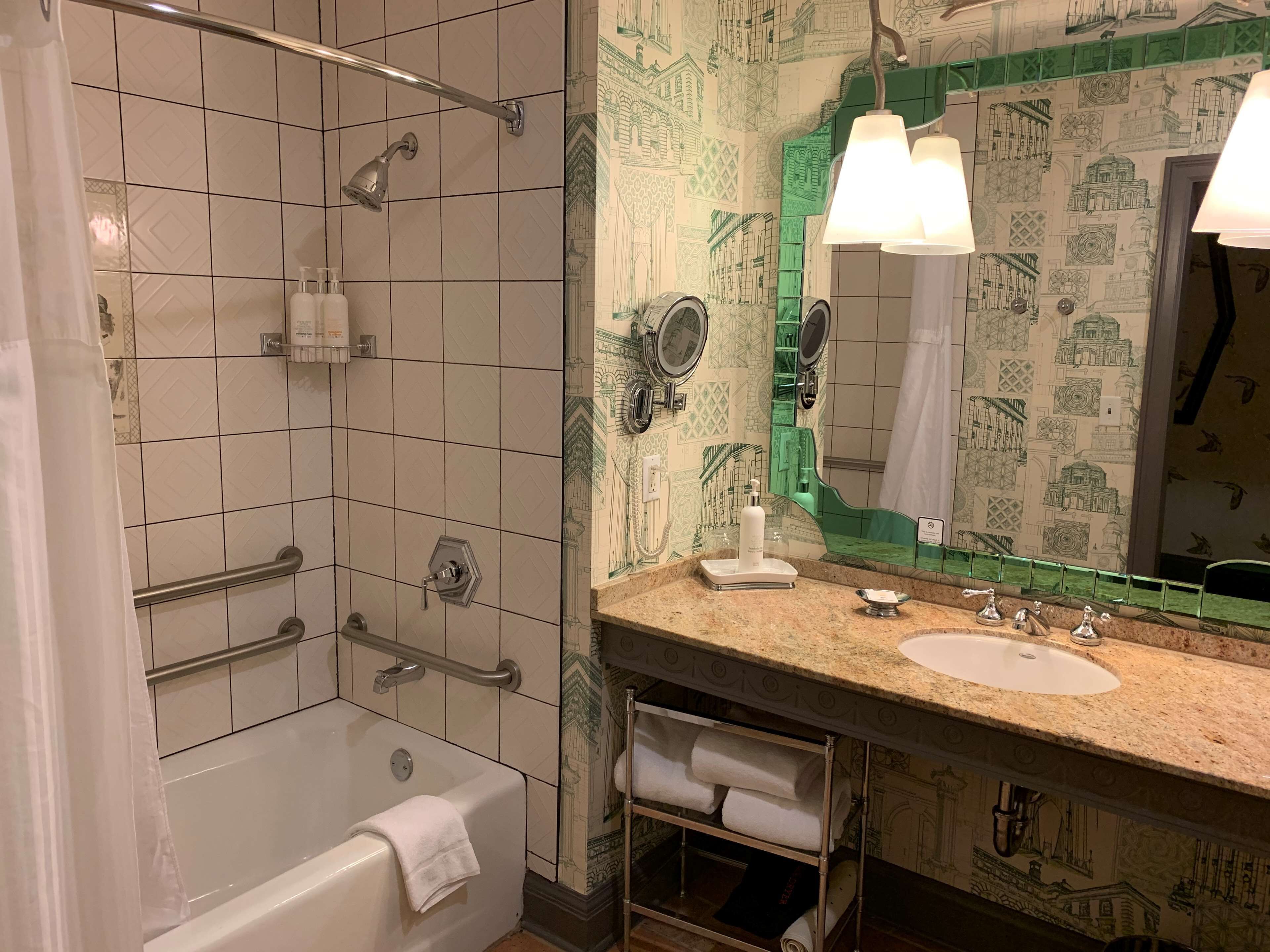 Ein Badezimmer mit Dusche, Badewanne, Waschtisch und einem großen Spiegel.