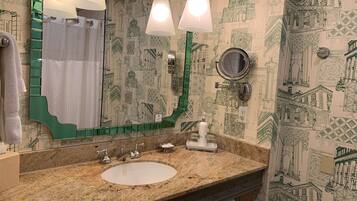 A bathroom with a sink, mirror, and green towel rack.