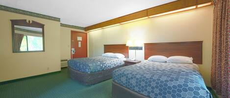A hotel room with two beds, a nightstand, a lamp, and a window with curtains.
