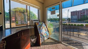 A reception area with a map, a magazine rack, and a view of the street outside. - Broadway Inn (Portland)