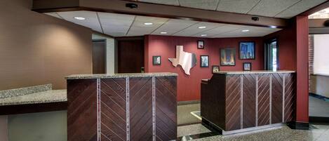 A reception area with a reception desk, a wall-mounted Texas map, and framed pictures.