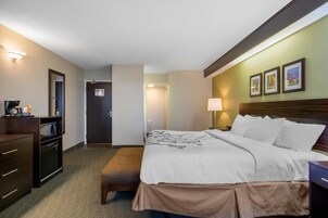Una habitación de hotel con cama, escritorio, cómoda y espejo.