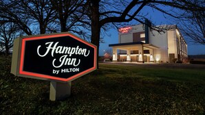 A Hampton Inn sign with a modern building in the background. - Hampton Inn Portland-Airport (Portland)