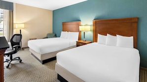 A hotel room with two beds, a desk, a chair, and a lamp. - Sonesta Essential Houston Hobby Airport (Houston)