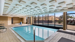 An indoor swimming pool with clear blue water, surrounded by tiled flooring and a ceiling with geometric patterns. - Sonesta Essential Houston Hobby Airport (Houston)