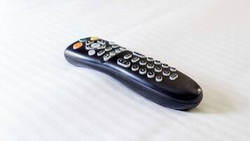 A black remote control with a skull and crossbones design on the top.
