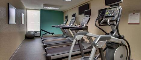 A fitness center with treadmills, elliptical machines, and stationary bikes.