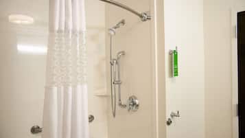 A shower area with a glass door, a showerhead, and a handheld shower attachment.
