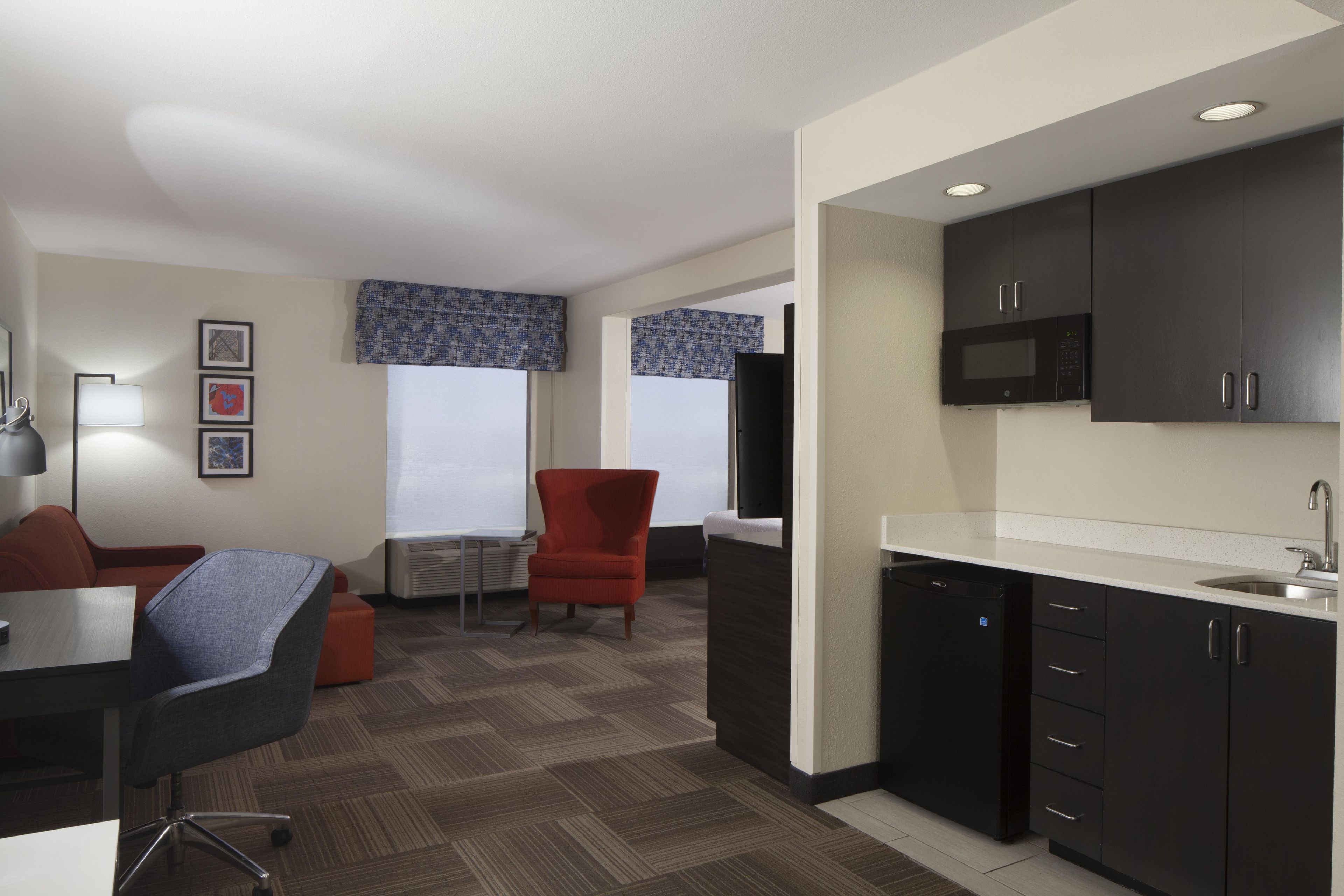 Una habitación de hotel moderna con kitchenette, comedor y zona de estar.