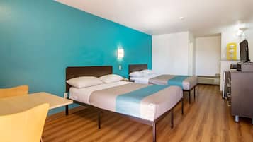A hotel room with two beds, a desk, and a chair.