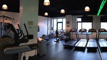 Een sportschool met loopbanden, elliptische trainers en gewichten.