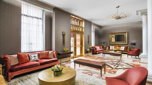 A spacious living room with a red sofa, a round coffee table, and a red armchair.