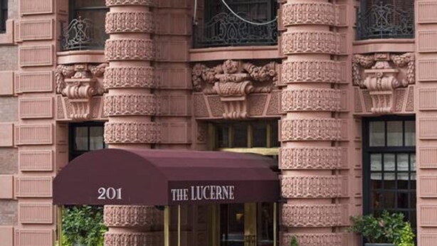 A building with ornate architectural details, an American flag, and a marquee sign for "The Lucerne" at address 201.
