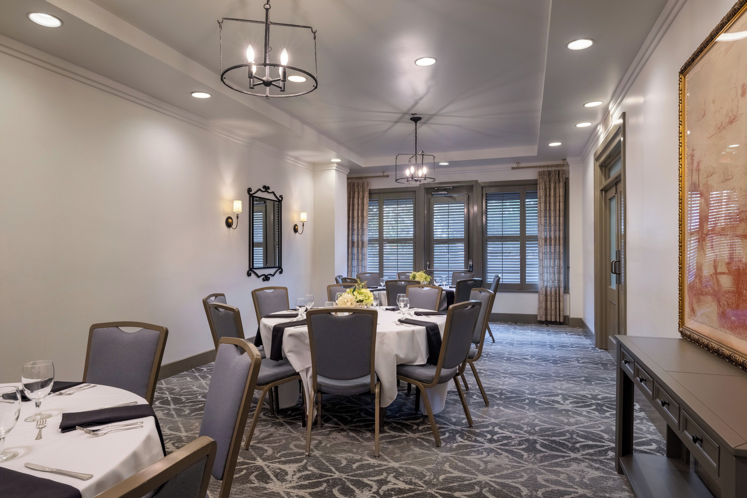 A conference room with a round table, chairs, and a chandelier.