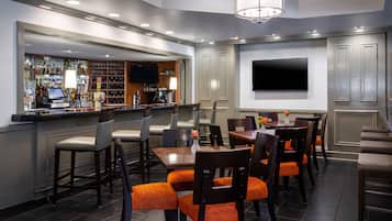 A bar area with a wine rack, bar counter, and seating area with tables and chairs.