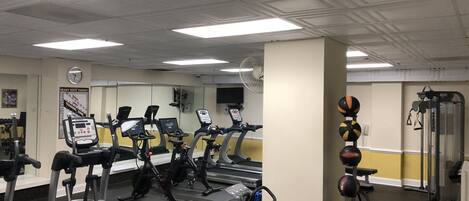 A gym with treadmills, stationary bikes, and weightlifting equipment.