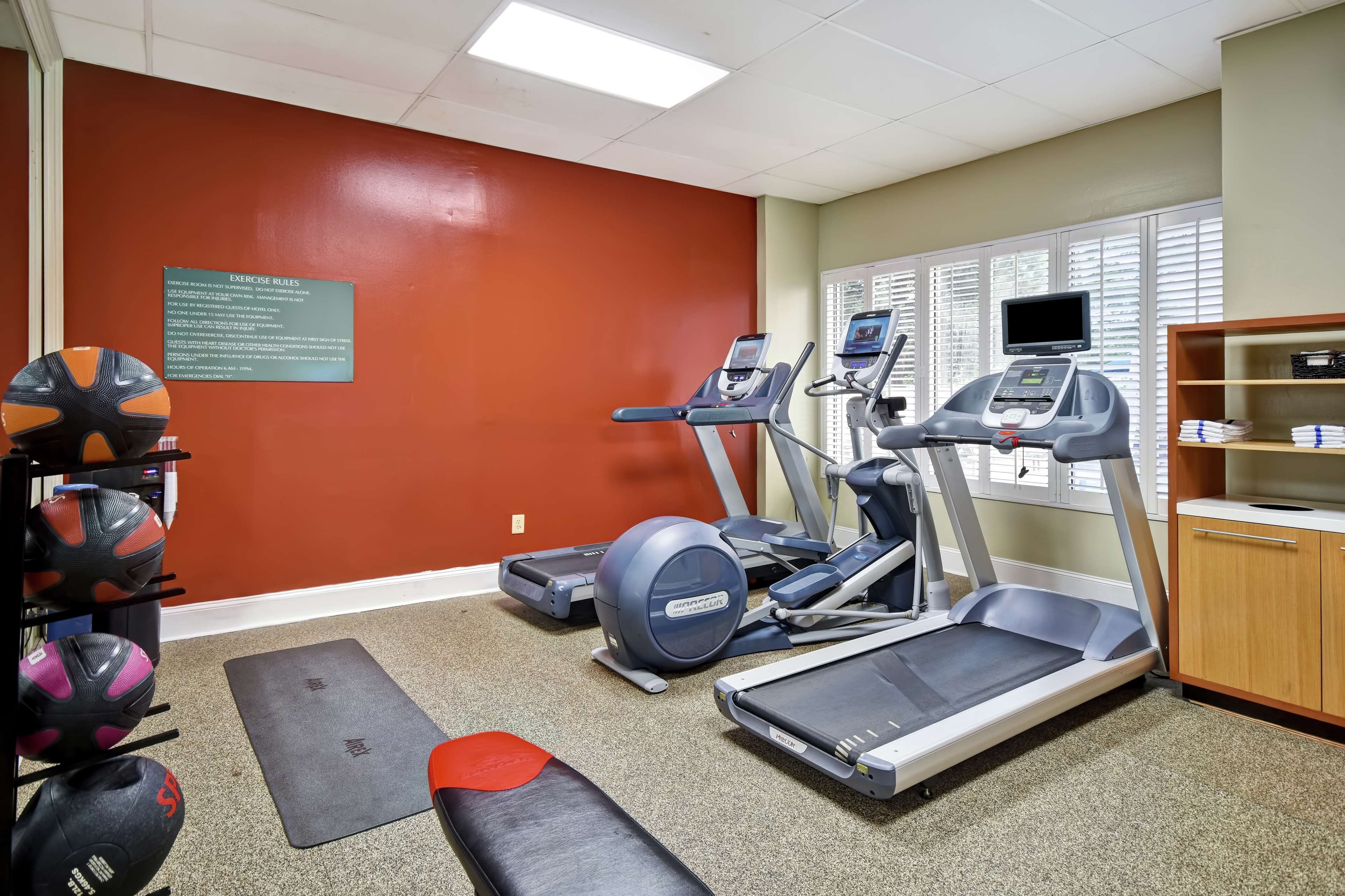 A gym with treadmills, a stationary bike, and weightlifting equipment.