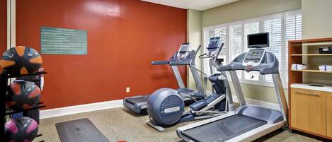 A gym with treadmills, a stationary bike, and weightlifting equipment.