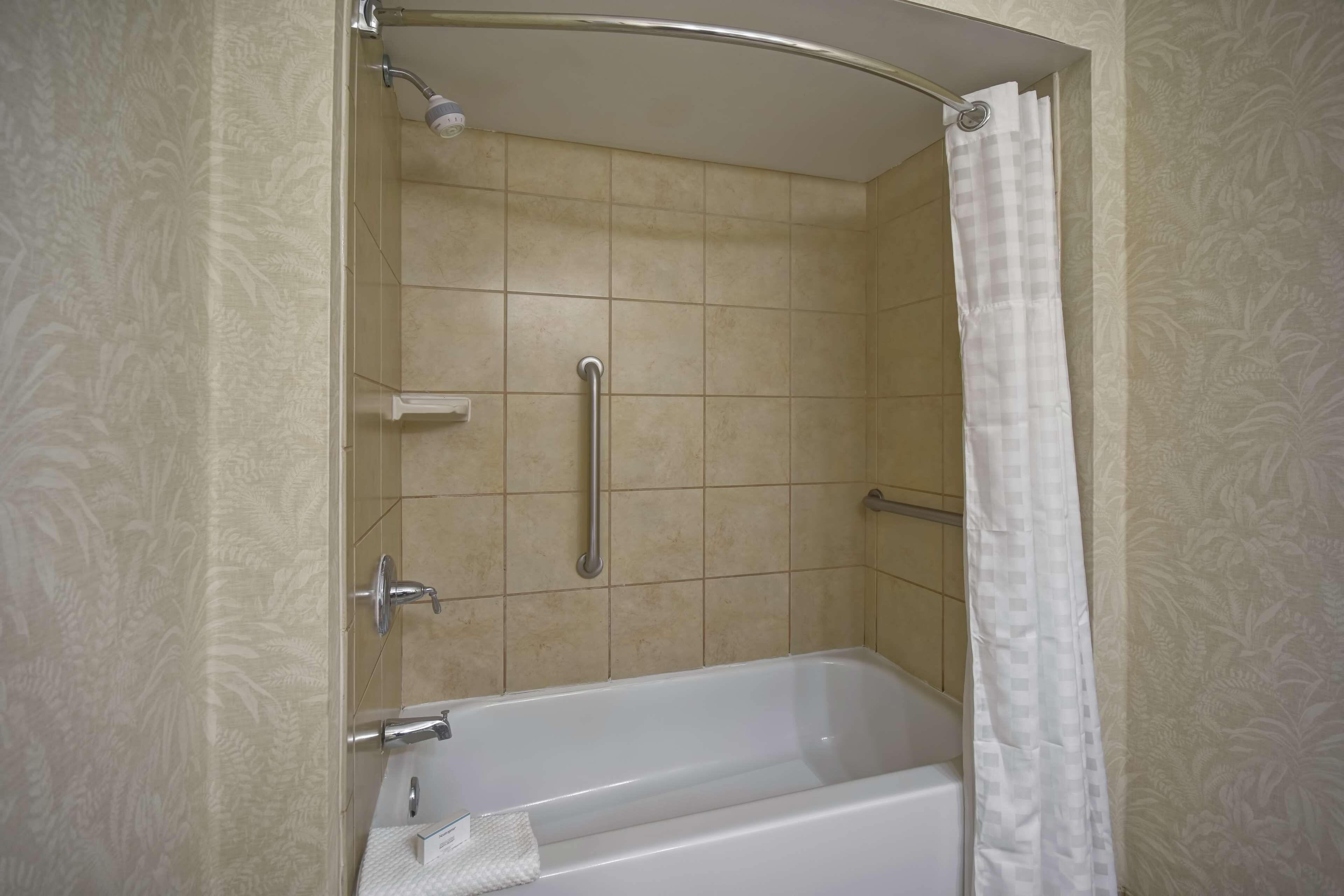 Un baño con bañera, ducha y baranda.
