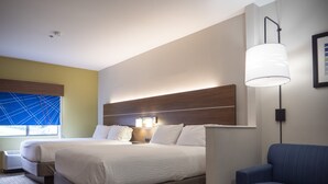 A hotel room with two beds, a sofa, a lamp, and a window with blinds. - Holiday Inn Express & Suites Greenville Airport by IHG (Greer)
