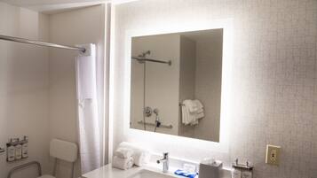 A modern bathroom with a shower, a sink, and a mirror.